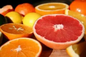 Sliced citrus fruits including grapefruit, oranges, and lemons arranged on a surface