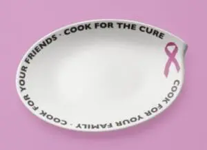 White ceramic dish with pink ribbon and "Cook for the Cure" text on pink background