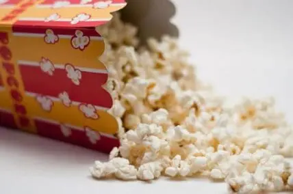 Popcorn spilling from a red and yellow striped container
