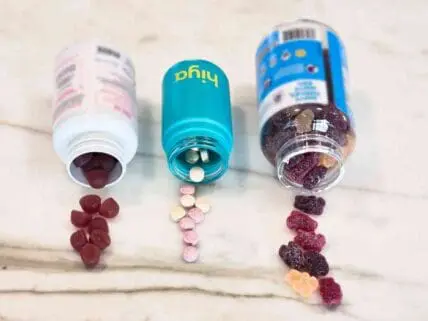 Image of three bottles of probiotics for kids, different brands in different colored bottles, with kids probiotic gummies and tablets spilling out