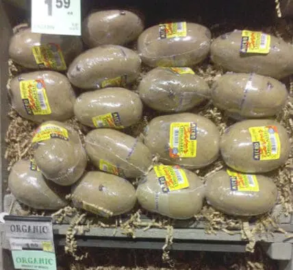 Organic potatoes individually wrapped in plastic at a grocery store display