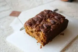 Chocolate pecan loaf cake on a white plate with a fork