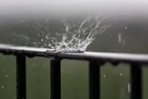 Rainwater splashing on a metal gutter during heavy rain