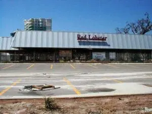 Abandoned Red Lobster restaurant with empty parking lot and boarded windows