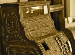 Ornate vintage cash register with decorative brass detailing and numerical keypad