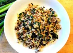 Colorful quinoa salad with kale, corn, and vegetables in a white bowl