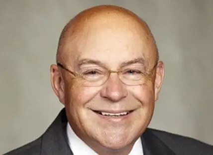 Monsanto executive in business suit and glasses smiling at camera