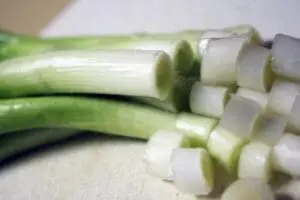 Sliced scallions showing white and green sections on a cutting board