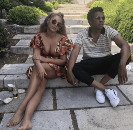 Two people sitting on outdoor steps wearing sunglasses