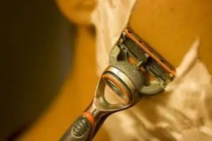 Close-up of a safety razor with soap suds on the blade head