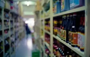 Shelves of bottled beverages in a refrigerated grocery store aisle