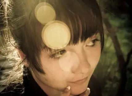 Woman with glowing skin and bokeh lights in background