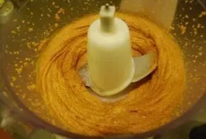 Creamy peanut butter in food processor with mixing blade