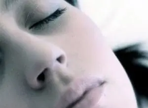 Woman's face in peaceful sleep with closed eyes and relaxed expression