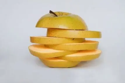 Golden apple sliced into pieces showing fresh interior flesh
