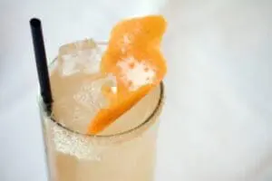 Fizzy cocktail with sugared rim and orange peel garnish