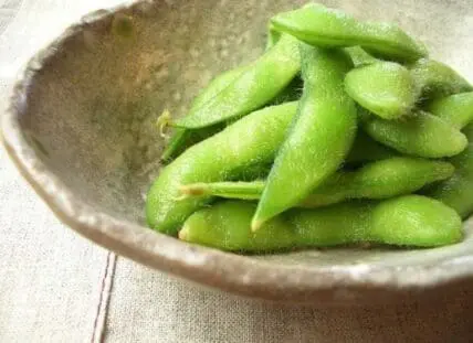 Fresh edamame pods in a ceramic bowl