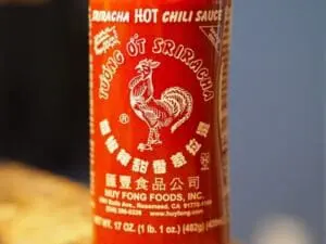 Bottle of Huy Fong sriracha hot chili sauce with rooster logo