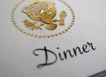 White dinner card with gold presidential seal emblem