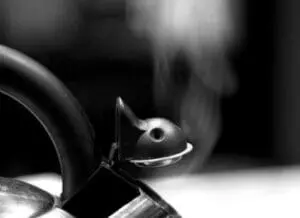 Close-up of essential oil diffuser nozzle releasing aromatic steam in black and white