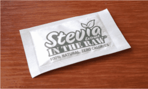 Single-serve stevia sweetener packet on wooden surface
