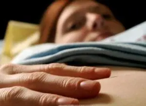Person resting hand on stomach while reading