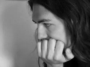 Woman with hand to mouth looking stressed and worried in black and white portrait