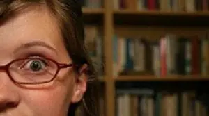 Woman wearing glasses in front of bookshelf