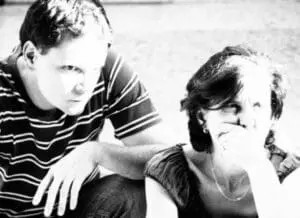 Two people sitting together, one comforting the other who appears stressed or worried.