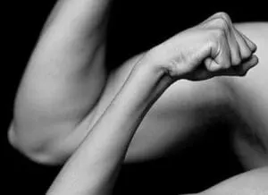 Woman flexing arm muscle in black and white