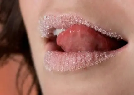 Close-up of lips with sparkling sugar coating and red interior visible