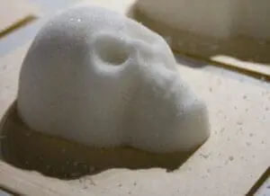 A pile of white sugar with a hole carved into it on a white plate