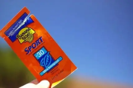 Banana Boat Sport SPF 30 sunscreen packet held up against blue sky