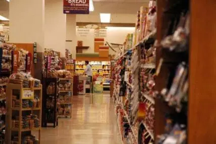 Supermarket aisle stocked with packaged food products and cereal boxes