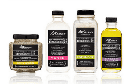 Four S.W. Basics of Brooklyn skincare products in glass bottles and jars with black labels