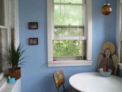 Blue dining room with round white table repurposed from old kitchen furniture