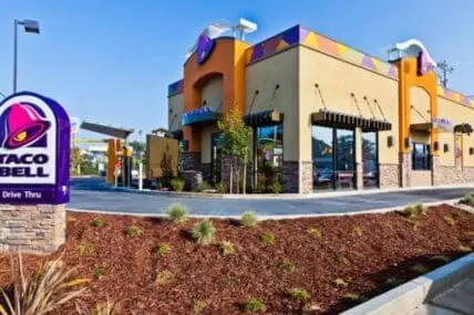 Taco Bell restaurant exterior with purple signage and drive-thru window