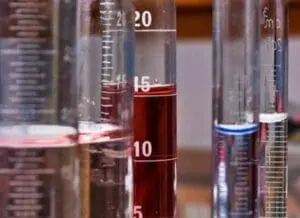Laboratory beakers and test tubes containing red liquid samples
