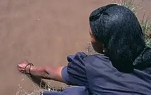 Person releasing a fish into murky water