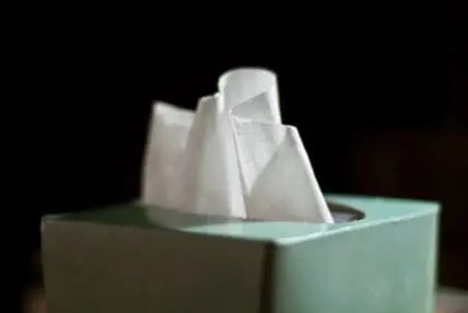 White tissues in a mint green box against a dark background