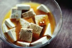Cubed tofu in a brown broth in a clear bowl