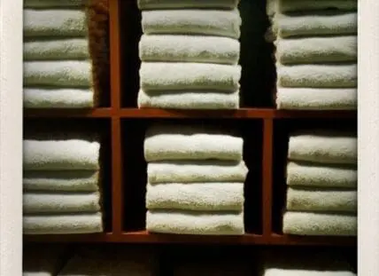 Stacked folded organic cotton towels on wooden shelves
