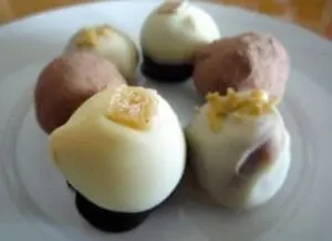 White chocolate and cocoa gingerbread truffles garnished with gold sugar on white plate