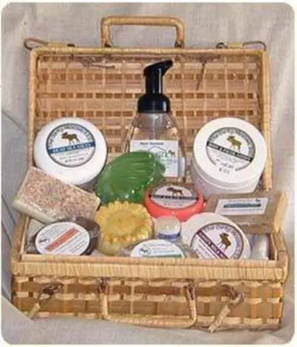 Wicker basket filled with natural skincare and bath products including soaps, creams, and a foam