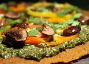 Gourmet appetizer with pesto spread, mushrooms, and roasted vegetables on toasted bread