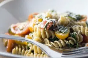 Plate of rotini pasta with roasted vegetables and herbs
