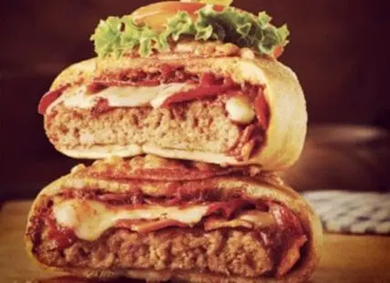 Stacked fried chicken sandwiches with cheese, tomato, and lettuce