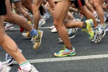 Group of runners jogging together on a city street during a race