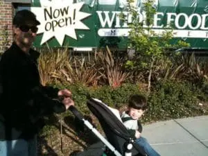 Man and child outside a Whole Foods Market storefront