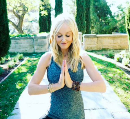 Sophie Uliano in meditation pose at a wellness retreat garden
